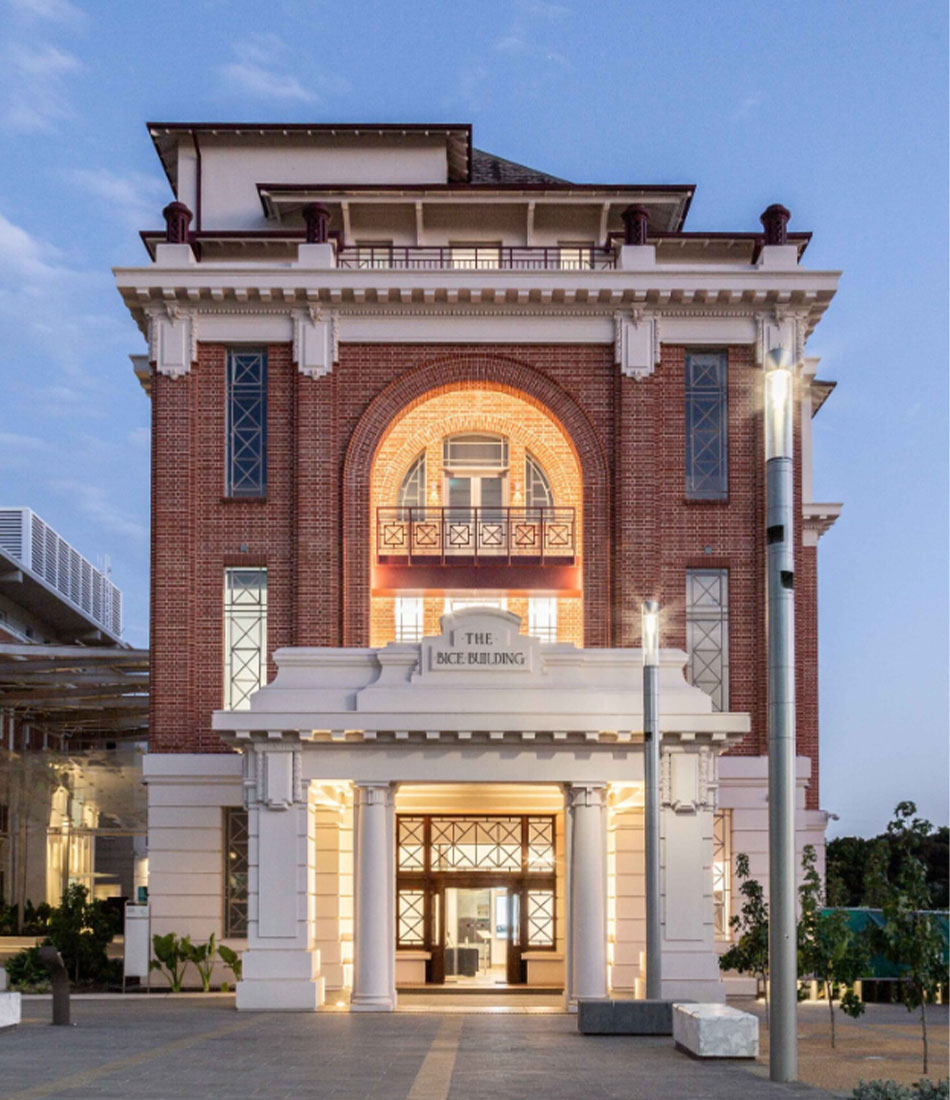 Bice Building entrance illuminated at dusk — Lot Fourteen refurbishment