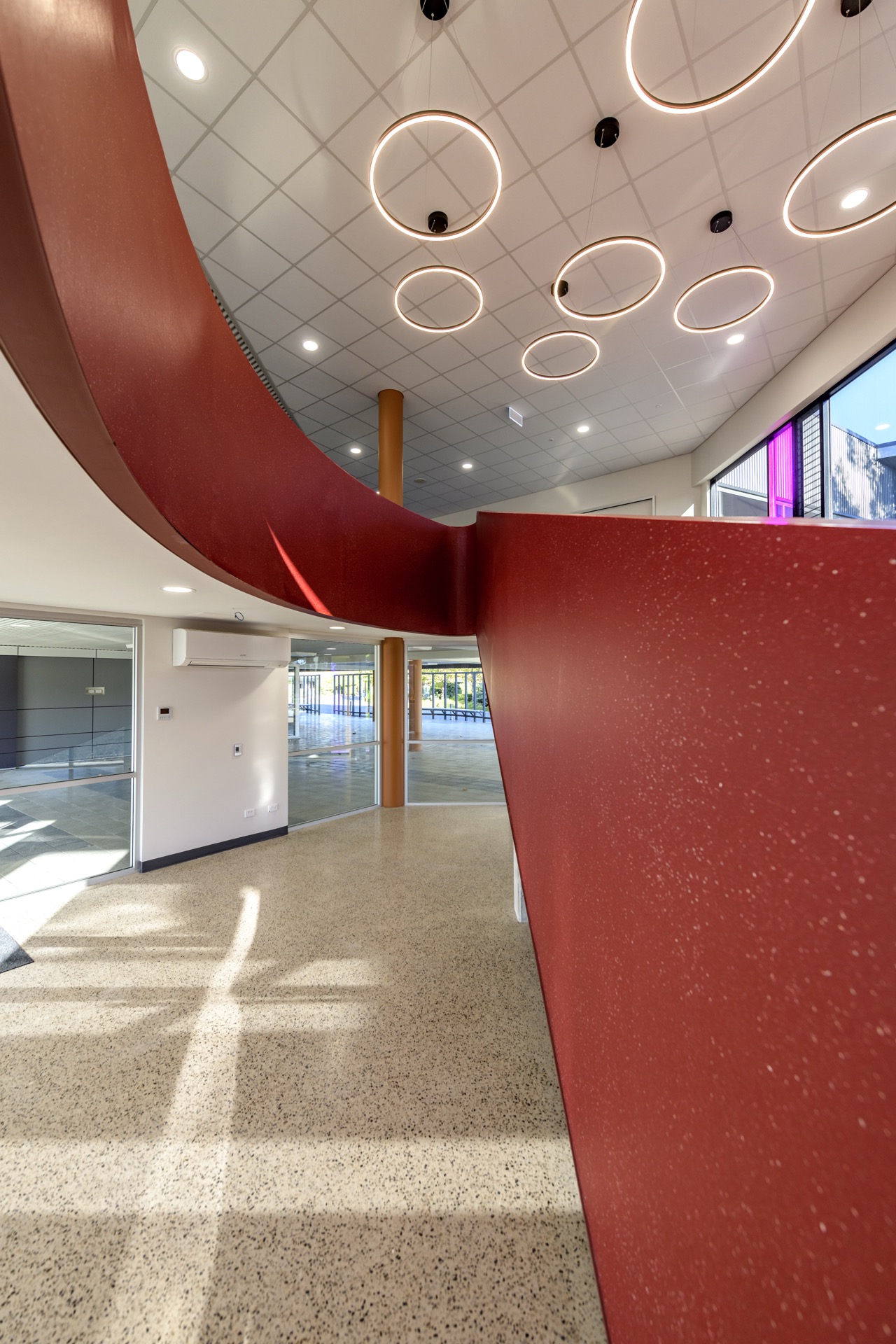 Polished concrete floor with red vinyl stair feature — Faith Lutheran College, Adelaide
