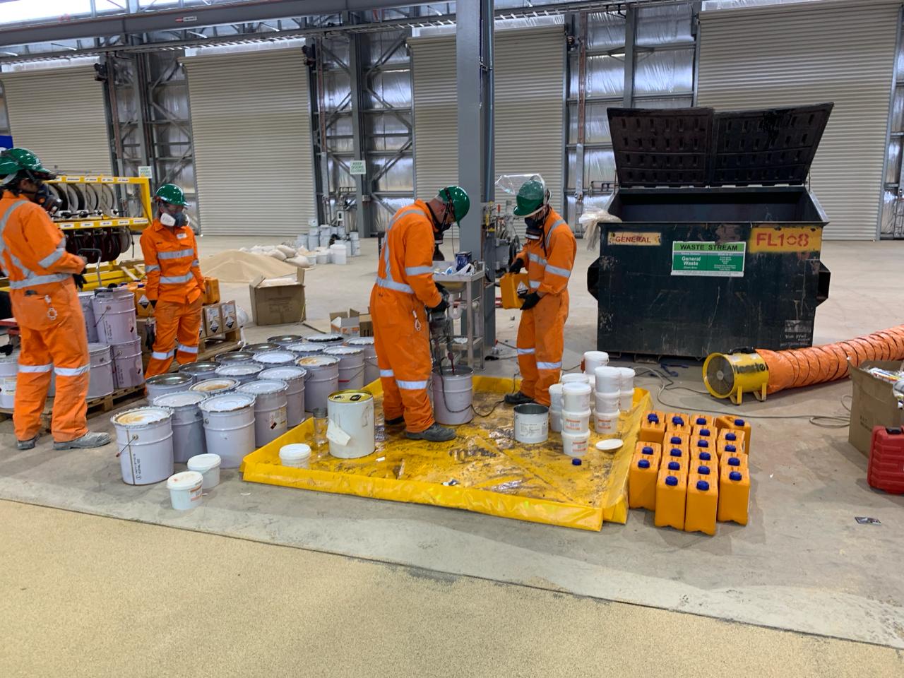 Crew preparing epoxy coating materials — Olympic Dam workshop Adelaide
