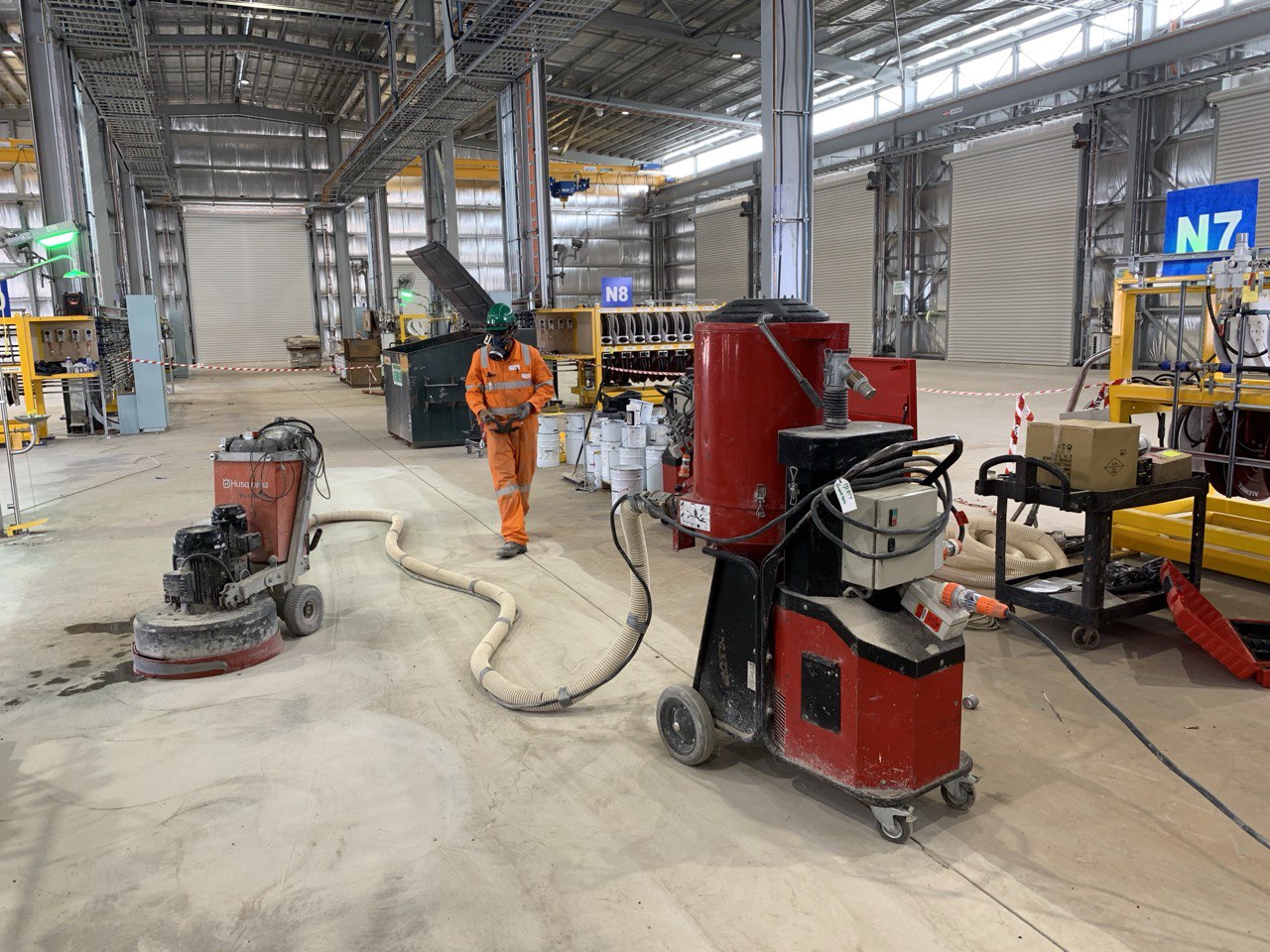 Floortek crew operating concrete grinder — Olympic Dam Surface Workshop expansion