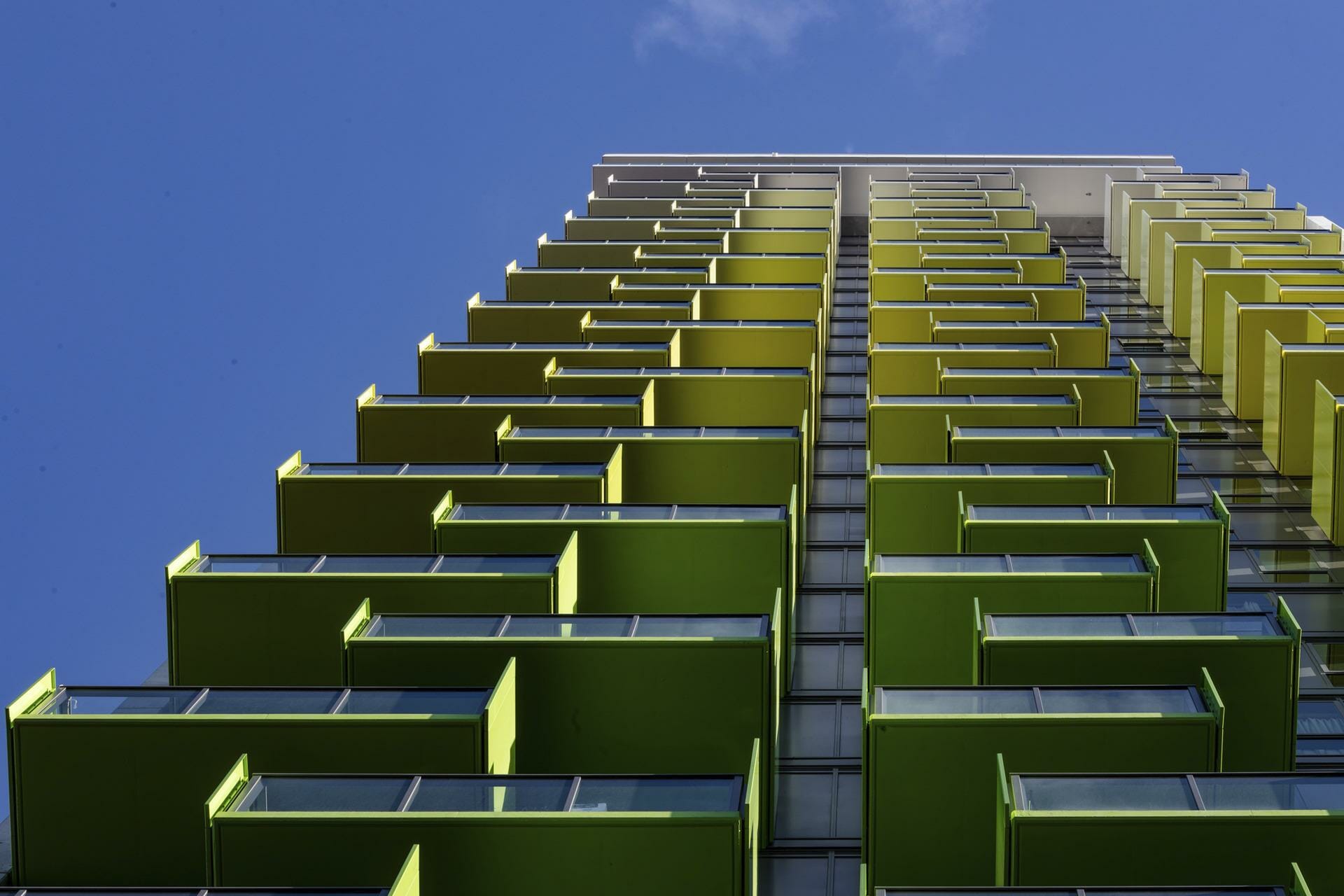 Kodo Apartments — low-angle view of green glass balconies