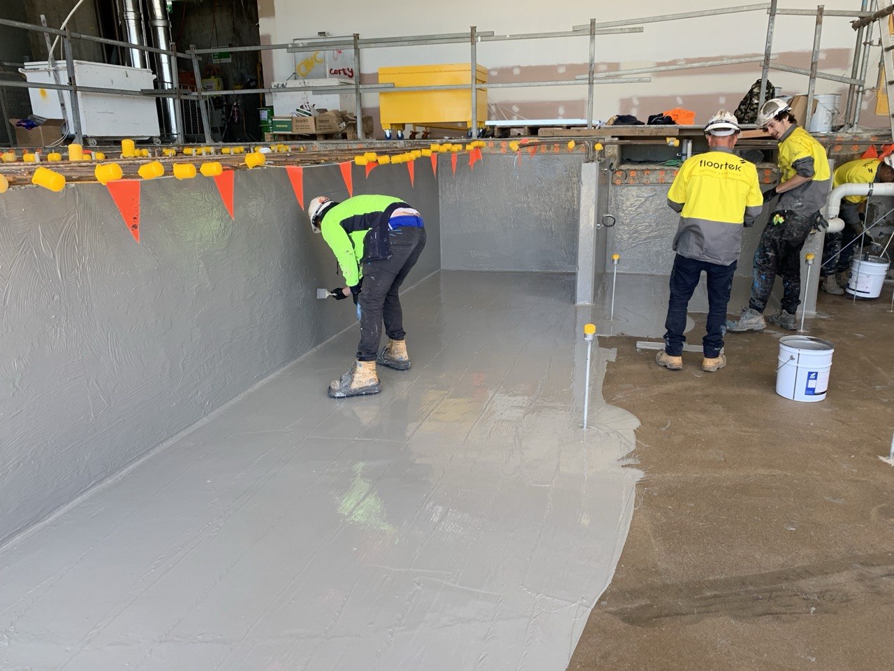 Floortek crew applying waterproofing membrane to pool shell — SkyCity Adelaide Casino