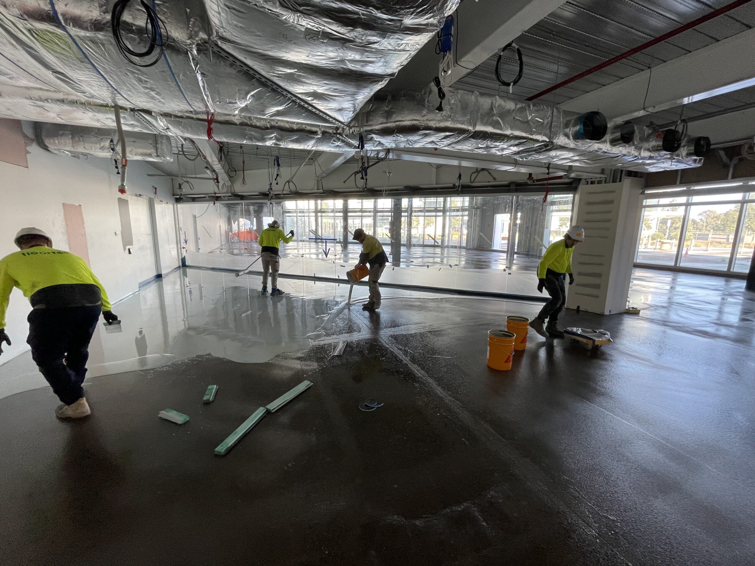 Self-levelling epoxy being poured and spread — Vickers Vimy Exhibition Space Adelaide Airport